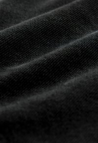 Tissu noir présentant une texture douce et lisse avec des lignes horizontales subtiles et un motif de tissage uniforme, idéal pour divers vêtements.