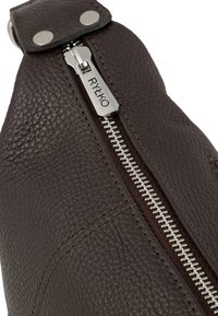 Brown leather bag featuring a textured surface, silver zipper with a pull tab, and metal studs. Visible stitching adds detail.