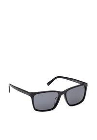 Lunettes de soleil rectangulaires noires avec des verres teintés foncés et des branches fines, légèrement inclinées vers la droite sur fond blanc.