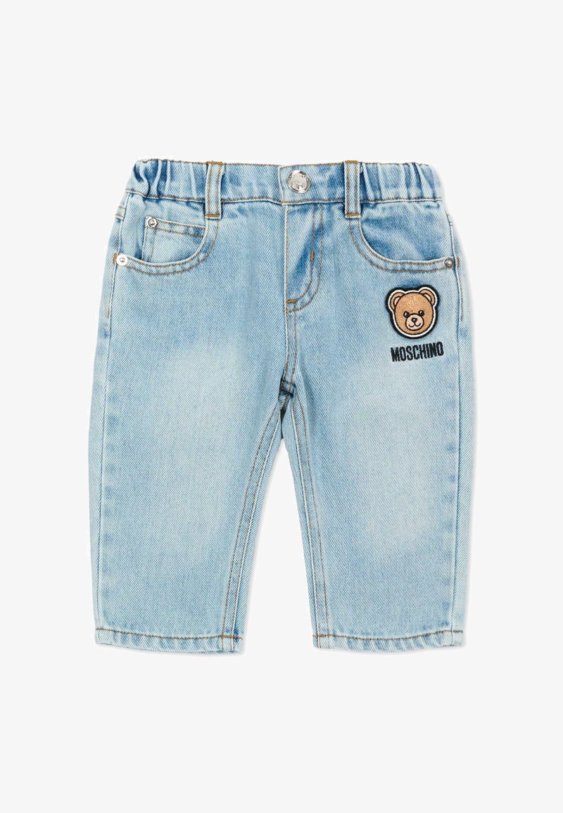 Pantalones de mezclilla azul claro para niño pequeño con cintura elástica, bolsillos frontales, cierre con botón y parche de oso de peluche con el texto "Moschino" en la pierna derecha.