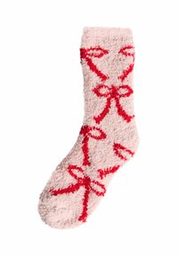 Calcetín rosa de felpa con patrones de cintas rojas, textura suave, largo hasta el tobillo y diseño sin costuras en los dedos. Ideal para mantener el calor y la comodidad.