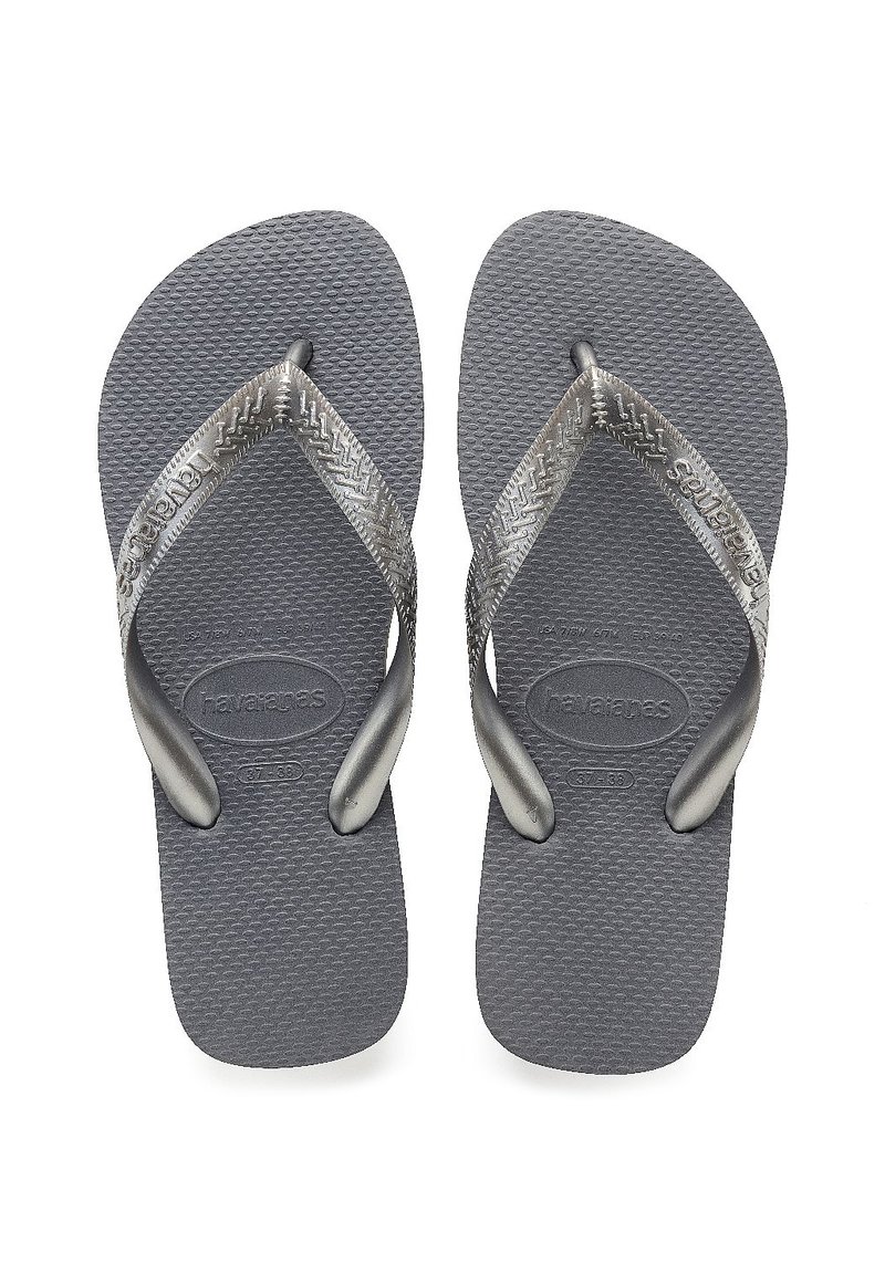 Grå Havaianas flip-flops med teksturerte gummisåler og metalliske stropper med et sikksakkmønster, designet for uformell bruk.