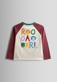 Pika varrukatega särk marooni värvi raglan varrukatega. Kreemivärvi keha peal on värvikad, tikitud tähed ja loomade näod, mis ütlevad "ROOAR!"
