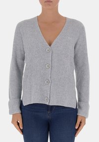 Cardigan grigio a costine con scollatura a V profonda, cinque bottoni e maniche lunghe. Presenta una texture liscia e un orlo leggermente accorciato.
