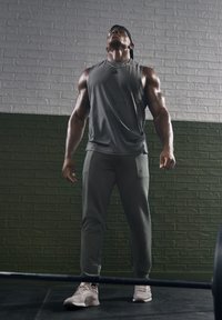 Vêtements de sport dans un haut sans manches gris foncé et un pantalon gris clair, avec une coupe slim, un tissu respirant et un design léger.