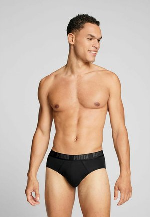 Black men's briefs with a thick Puma logo waistband, featuring a smooth fabric texture and a snug fit, emphasizing body contours.