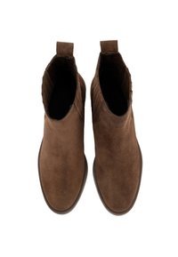 Un par de botas de tobillo de ante marrón con paneles laterales elásticos y lengüetas, vistas desde arriba sobre un fondo blanco.