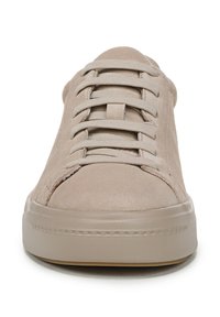 Beige suede sneakers with a rounded toe, featuring flat laces, stitched accents, and a textured rubber sole.