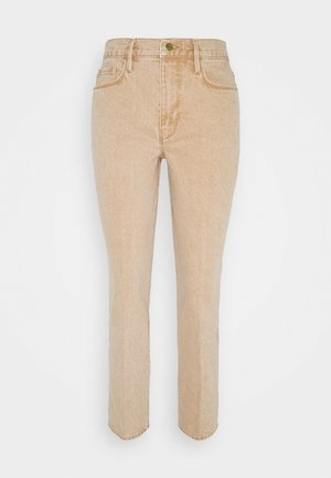 Jean en denim beige avec une coupe ajustée, cinq poches et une braguette à boutons. Présente un léger délavage et un ourlet cousu.