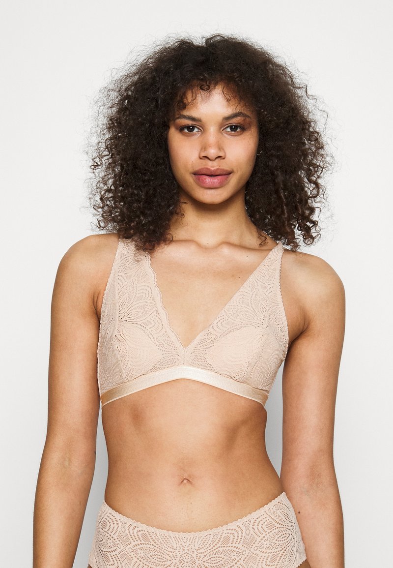 Blonde bralette i nude farge med bølget v-hals, brede stropper og sateng underbånd, med intrikate blomster mønstre.