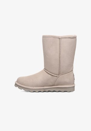 Beige Wildleder-Ankle-Boot mit runder Zehenpartie, flacher Gummisohle und dekorativer seitlicher Naht. Verfügt über ein flaches Design und eine glatte Textur.