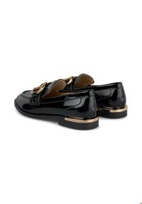Schwarze Lackleder Slipper verfügen über einen niedrigen Absatz, vergoldete Hardware-Akzente und eine flache Sohle mit strukturierter Oberfläche.
