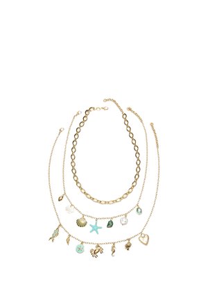 Trois colliers en ton or comprennent une chaîne simple, une chaîne avec un pendentif étoile de mer et coquillage, et une chaîne avec des pendentifs à thème marin et en forme de cœur.