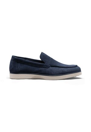 Mocassin à enfiler en daim bleu marine avec semelle texturée beige clair, petit talon et bout arrondi, présenté de profil.