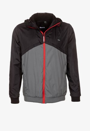 Hooded jacket made of lightweight fabric. Features a black upper section, gray lower section, red zipper, and elastic cuffs.