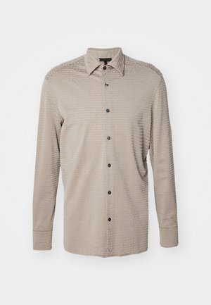 Beige overhemd met lange mouwen en een getextureerd patroon, met een button-down kraag en zwarte knopen. Bevat subtiele tonale branding en heeft een ontspannen pasvorm.