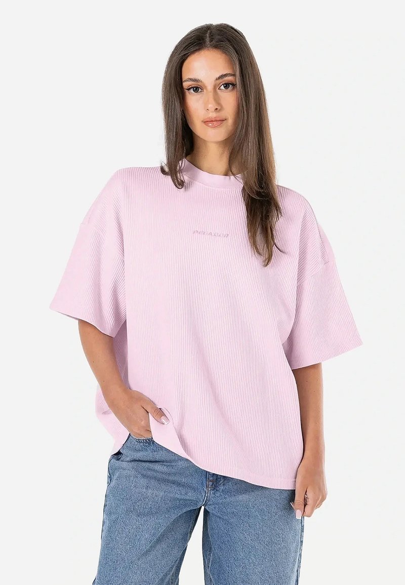 Svetloružové oversized tričko vyrobené z rebrovanej látky, s krátkymi rukávmi, vysokým výstrihom a Diskrétnym brandingom na prednej strane.