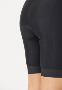 Svarta sportshorts tillverkade av ett mjukt elastiskt tyg. Har en tight passform, längd till mitten av låret och minimala sömmar för komfort och bekvämlighet.