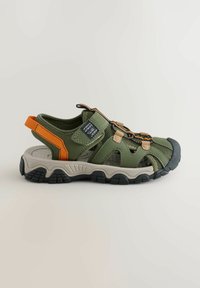 Sandale de sport outdoor verde măsliniu cu accente portocalii, curele reglabile, panouri din plasă și talpă robustă neagră.