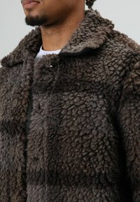 Brown, textured faux fur coat with a soft, shaggy appearance. Features a spread collar and five button closures along the front.