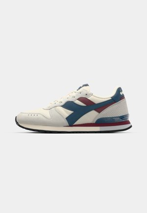 Sneaker aus cremfarbener Leinwand und blauer Wildleder mit kastanienbraunen Akzenten. Runde Zehenform, Schnürdesign, gepolsterter Kragen und strukturierte Gummisohle.