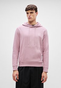 Hea roosa dressipluus pehme kangaga, millel on ees tasku ja reguleeritavad paelad. Rinnal väike logo.