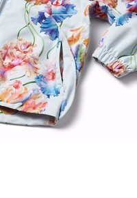 Blomsterjacka med ett ljusblått satintyg, färgglada blommönster, elastiska ärmslut och en dragkedja på sidan.