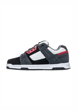 Gray and black athletic shoe with a textured suede and mesh upper, white midsole, red and gray accents, and a lace-up closure.
