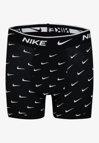 Melni bokseršorti ar baltiem Nike swoosh logotipiem rakstā, ar melnu jostu, kurā ir Nike zīmols, un maigu faktūru.