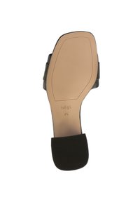 Svart klackskor med en texturerad sula, med ett slätt ovansidan. Innersulan är beige och märkt med varumärket och storlek.