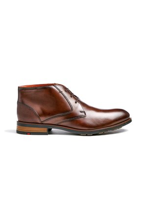 Braune Leder-Stiefeletten mit glatter Oberfläche, runder Zehenpartie und minimalistischem Schnürdesign. Mit strukturierten Akzenten und einem geschichteten Holzabsatz.