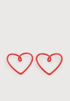 Punased südamekujulised kõrvarõngad, mis on valmistatud painduvast materjalist ja mille iga südame keskel on lokkev aktsent.