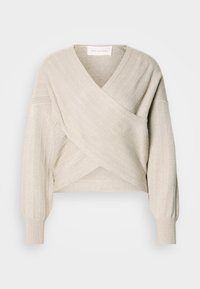 Pull cache-cœur beige en tricot avec manches longues, poignets côtelés et col en V croisé.