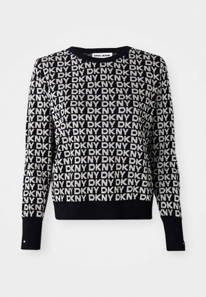 Svart og hvit DKNY jeans genser med gjentakende logo mønster, rund hals, lange ermer, ribbestrikket nederkant, og knappdetalj på ermene.