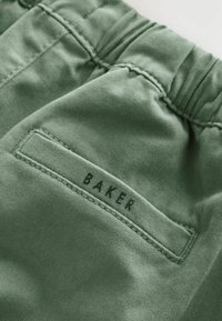 Zöld pamutnadrág, texturált felülettel, fekete "BAKER" felirattal, amely a hátsó zsebre van varrva. Rugalmas derékpánt a megfelelő illeszkedésért.