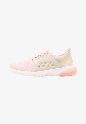 Chaussure de sport rose clair et beige avec bout en mesh, fermeture à lacets, trous de ventilation sur les côtés, et semelle blanche avec accent rose.