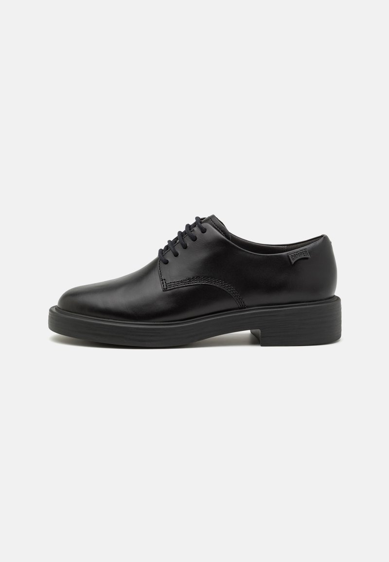 Scarpe oxford in pelle nera con punta tondeggiante, allacciatura a cinque occhielli, dettagli di cucitura sottili e una robusta suola in gomma.