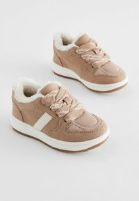 Baskets en suède beige avec doublure en fausse fourrure, lacets tressés et une rayure blanche. Comportent une semelle en caoutchouc avec un motif texturé pour une meilleure adhérence.