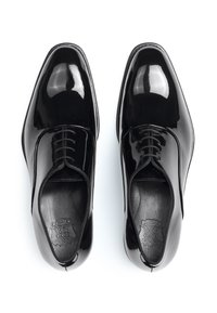 Chaussures habillées en cuir verni noir avec une finition brillante, présentant un bout pointu, un laçage sur le devant et un détail de doublure intérieure lisse.