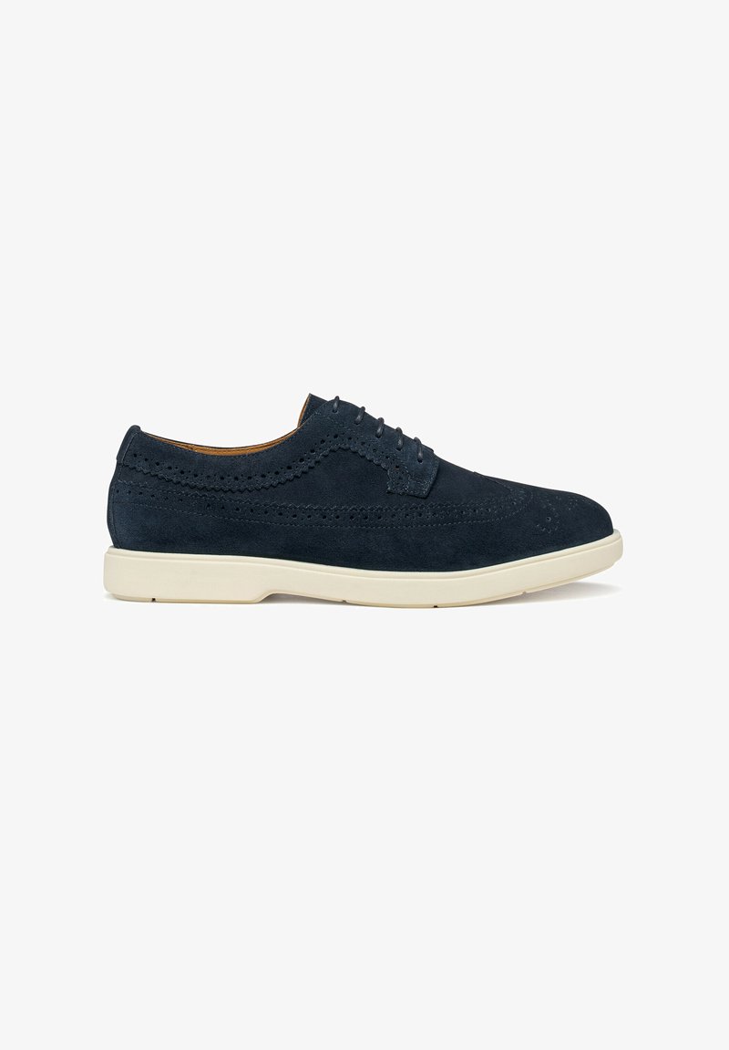 Chaussures habillées en daim bleu marine avec détails brogue, bout rond et semelle en caoutchouc blanche contrastante. Dotées de cinq œillets et d'une texture lisse.