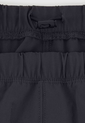 Ceinture élastique noire avec fermeture à cordon de serrage, dotée d'un tissu lisse et de détails de couture subtils. Ajustement réglable pour le confort.