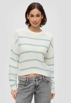 Pull en tricot blanc, légèrement court, avec des rayures horizontales bleu clair ; il a un col rond et des poignets côtelés. Assorti à un jean gris.