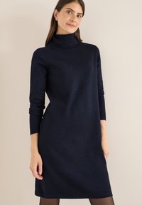 Abito turtleneck blu realizzato in un materiale morbido, con maniche lunghe e una vestibilità comoda, dotato di una texture liscia e un leggero lucido.