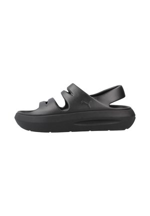 Sandalias tipo chancla negras con punta redondeada, diseño con recortes y suela acolchada. Fabricadas con material resistente y estilo minimalista.