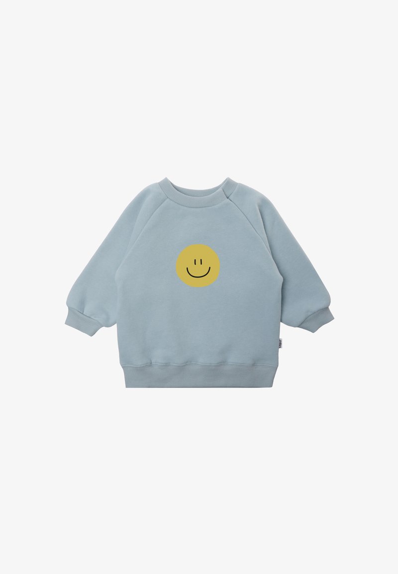 Hellblaues Sweatshirt aus weichem Stoff, mit einem runden gelben Smiley-Gesicht in der Mitte der Vorderseite und gerippten Bündchen.