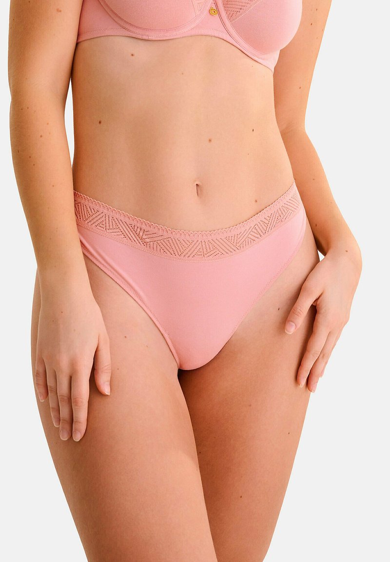 Panties roses avec une taille texturée à motif. Matériau doux avec une finition lisse et un design taille basse. Pas de logos ou de pièces métalliques visibles.