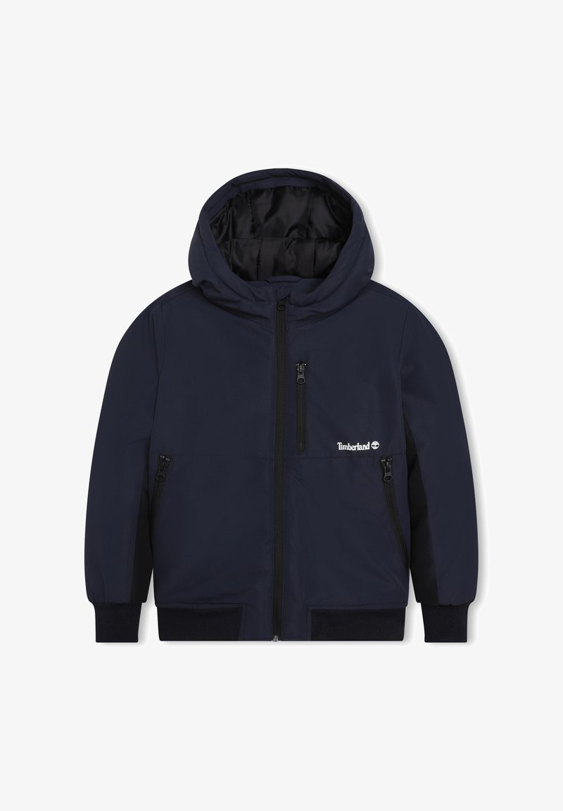 Námořnická modrá bunda s kapucí, s předním zipem, dvěma bočními kapsami na zip a vnitřním podšíváním. Obsahuje logo Timberland na levé hrudi.