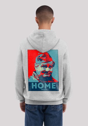 Gray hooded sweatshirt featuring a graphic print of a man in a red and blue color scheme. Text reads "HOME GUARD."