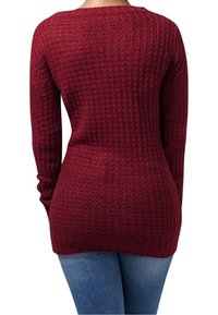 Maglione bordeaux con un motivo a maglia testurizzato, maniche lunghe e orlo a coste. Abbinato a jeans in denim blu. Vista posteriore.