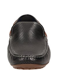 Schwarzer perforierter Lederschuh zum Hineinschlüpfen mit braunen Wildlederakzenten, abgerundeter Spitze und weißen Nähten. Flache Gummisohle mit Grippattern.